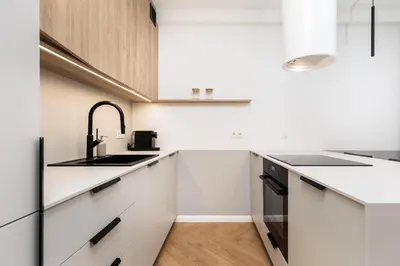 a white kitchen with white cabinets and a sink at Comfort Corner in Kraków - by Upstairs in Kraków
