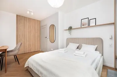 a bedroom with a large white bed and a table at Comfort Corner in Kraków - by Upstairs in Kraków
