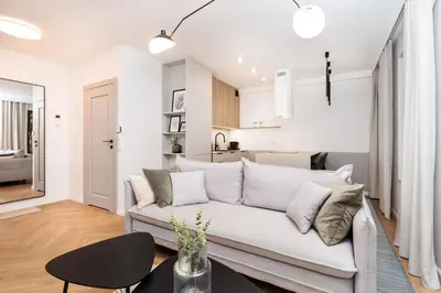 a living room with a white couch and a table at Comfort Corner in Kraków - by Upstairs in Kraków