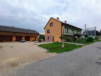 a yellow house with a car parked next to a building at Studio nad S-ką in Brzuchania