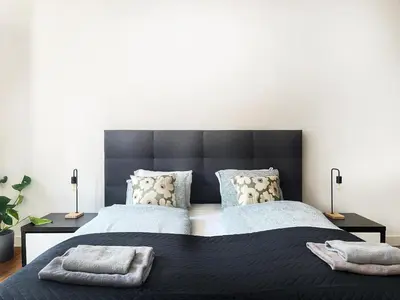 a bedroom with a large black bed with two pillows at Beautiful Apartment for 8 people in Cracow's heart in Kraków