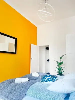 a bedroom with a blue bed with a yellow wall at Beautiful Apartment for 8 people in Cracow's heart in Kraków