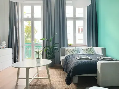 a bedroom with a bed and a table and windows at Beautiful Apartment for 8 people in Cracow's heart in Kraków