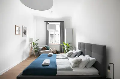 a bedroom with a bed with a blue blanket at Beautiful Apartment for 8 people in Cracow's heart in Kraków