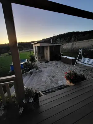 a view of a backyard with a wooden deck at Domek drewniany z sauną in Bieńkówka