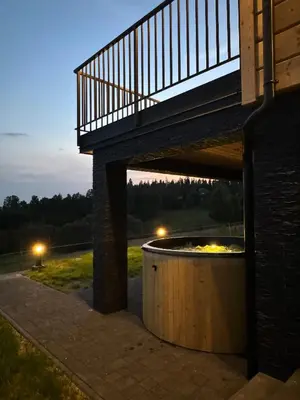 a deck with a fire pit under a building at Domek DE-Luxe BUFLAK in Nowy Targ