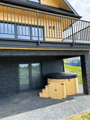 a bench sitting in front of a building at Domek DE-Luxe BUFLAK in Nowy Targ
