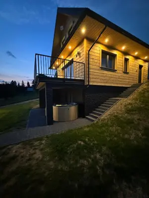 a house with lights on the side of it at Domek DE-Luxe BUFLAK in Nowy Targ