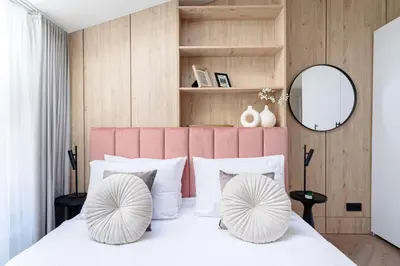a bedroom with a large bed with a pink headboard at Miodova20 by StayLab in Kraków