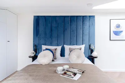 a bedroom with a large bed with a blue headboard at Miodova20 by StayLab in Kraków