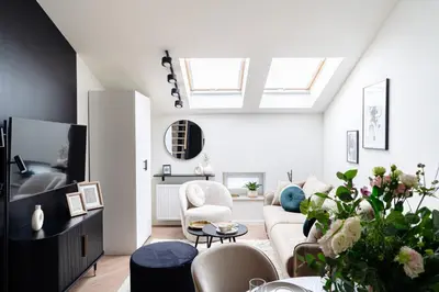 a living room with a vaulted ceiling with skylights at Miodova20 by StayLab in Kraków