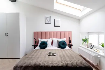 a bedroom with a large bed and a skylight at Miodova20 by StayLab in Kraków