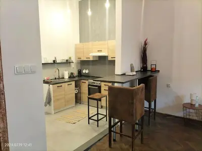 a kitchen with a counter and chairs in it at ChilLoud - apartament na Kazimierzu in Kraków