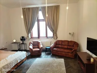 a bedroom with leather furniture and a bed and a window at ChilLoud - apartament na Kazimierzu in Kraków