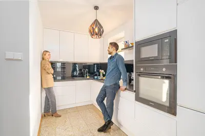 a man and woman standing in a kitchen at Penthouse in the Center - by Hosty in Kraków