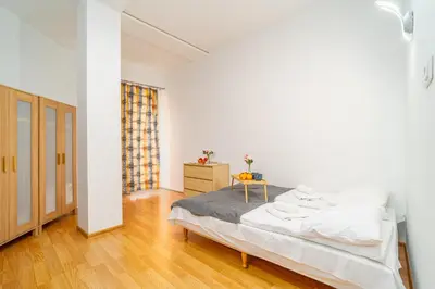 a white bedroom with a bed and a wooden floor at Penthouse in the Center - by Hosty in Kraków