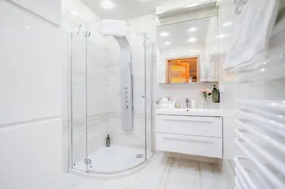a white bathroom with a shower and a tub and a sink at Penthouse in the Center - by Hosty in Kraków