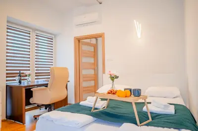 a room with two beds with a desk and a table at Penthouse in the Center - by Hosty in Kraków