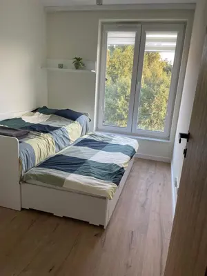 a bedroom with a bed and a large window at Apartament Zdunów in Kraków