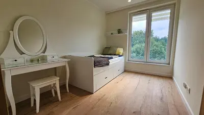a bedroom with a mirror and a bed and a window at Apartament Zdunów in Kraków