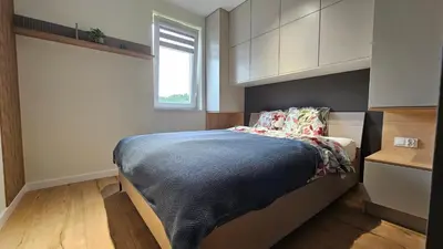 a bedroom with a bed with a blue blanket at Apartament Zdunów in Kraków
