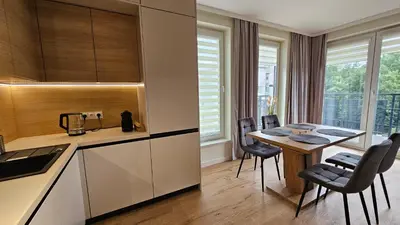 a kitchen with a table and chairs in a room at Apartament Zdunów in Kraków