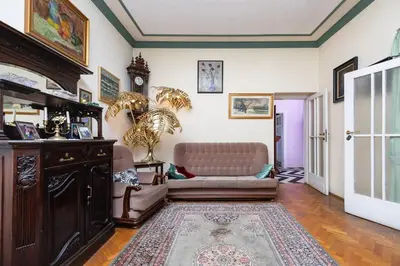 a living room with a couch and a clock on the wall at Fine Art Luxury Apartment 110 m2 , 3 min walk to Main Square in Kraków