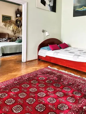 a bedroom with a bed and a red rug at Fine Art Luxury Apartment 110 m2 , 3 min walk to Main Square in Kraków