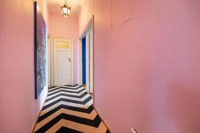 a hallway with a black and white rug in a pink wall at Fine Art Luxury Apartment 110 m2 , 3 min walk to Main Square in Kraków