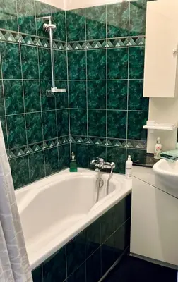 a green tiled bathroom with a tub and a sink at Fine Art Luxury Apartment 110 m2 , 3 min walk to Main Square in Kraków