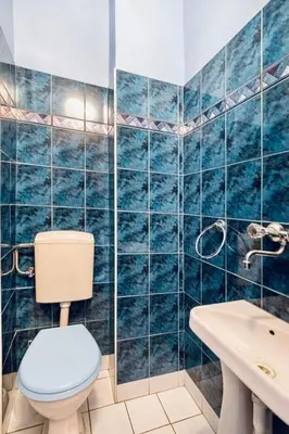 a blue tiled bathroom with a toilet and a sink at Fine Art Luxury Apartment 110 m2 , 3 min walk to Main Square in Kraków