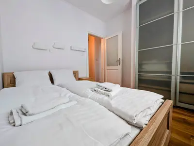 two beds in a bedroom with white sheets and towels at Dworska 1B by Homeprime in Kraków