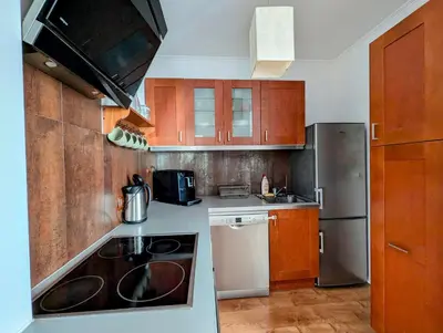 a kitchen with wooden cabinets and a stove top oven at Dworska 1B by Homeprime in Kraków