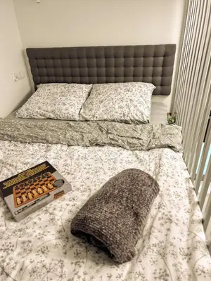 a bed with a pillow and a book on it at Szarów 414 in Szarów