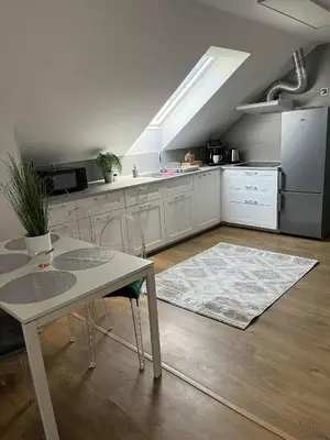 a dining room with a white table and chairs at Szarów 414 in Szarów