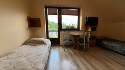 a bedroom with a bed and a table and a window at Noclegi u Basi in Klikuszowa