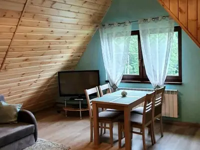 a living room with a table and chairs and a couch at Noclegi u Basi in Klikuszowa