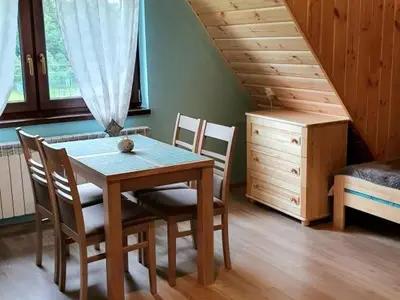 a dining room with a table and chairs in a room at Noclegi u Basi in Klikuszowa