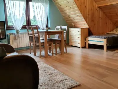 a living room with a table and chairs and a bed at Noclegi u Basi in Klikuszowa