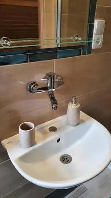 a sink in a bathroom with a mirror at Noclegi u Basi in Klikuszowa