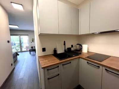 a kitchen with white cabinets and a counter top at Studio Karo in Kraków