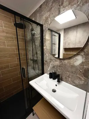 a bathroom with a sink and a shower and a mirror at Studio Karo in Kraków