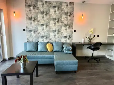 a living room with a blue couch in front of a wall at Studio Karo in Kraków