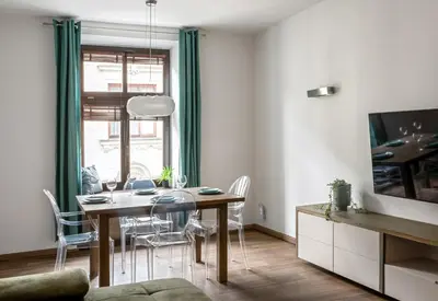 a dining room with a table and chairs and a tv at P19 Apartments in Kraków