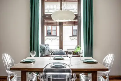 a dining room with a table with chairs and a window at P19 Apartments in Kraków