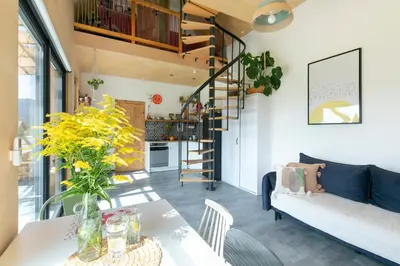 a living room with a table and a spiral staircase at Casa Dobra in Dobra