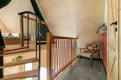 a room with a wooden staircase and a chair at Casa Dobra in Dobra