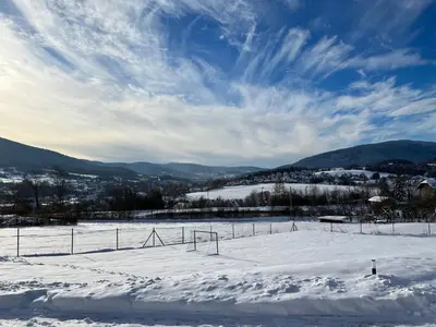 a snow covered field with a fence and mountains at Casa Dobra in Dobra