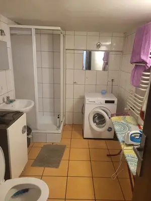 a bathroom with a washing machine and a sink at Grzegorzecka Room 3 in Kraków