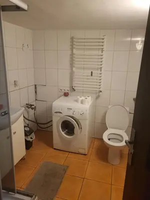 a bathroom with a washing machine and a toilet at Grzegorzecka Room 3 in Kraków